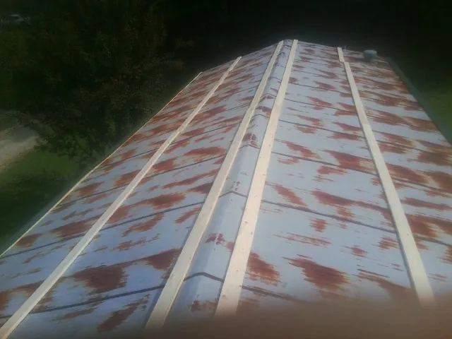 Rusted metal roof panels with new wood purlins before replacement — Storm Damage Roof Repair in Deanville by Roofing Brothers