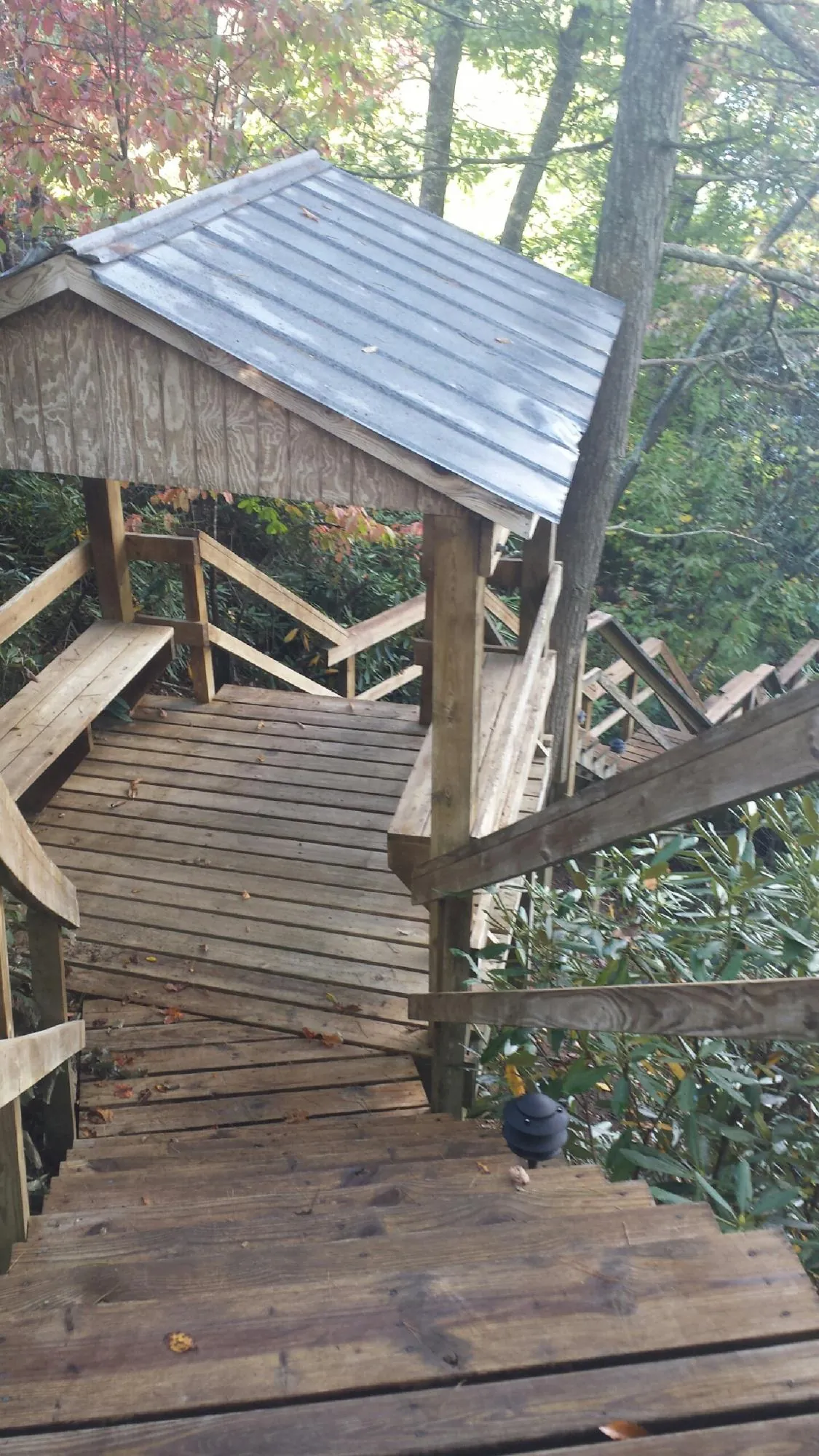 Metal roofed shelter over wooden steps on a wooded walkway — Skylight Repair & Installation work by our crew in Deanville