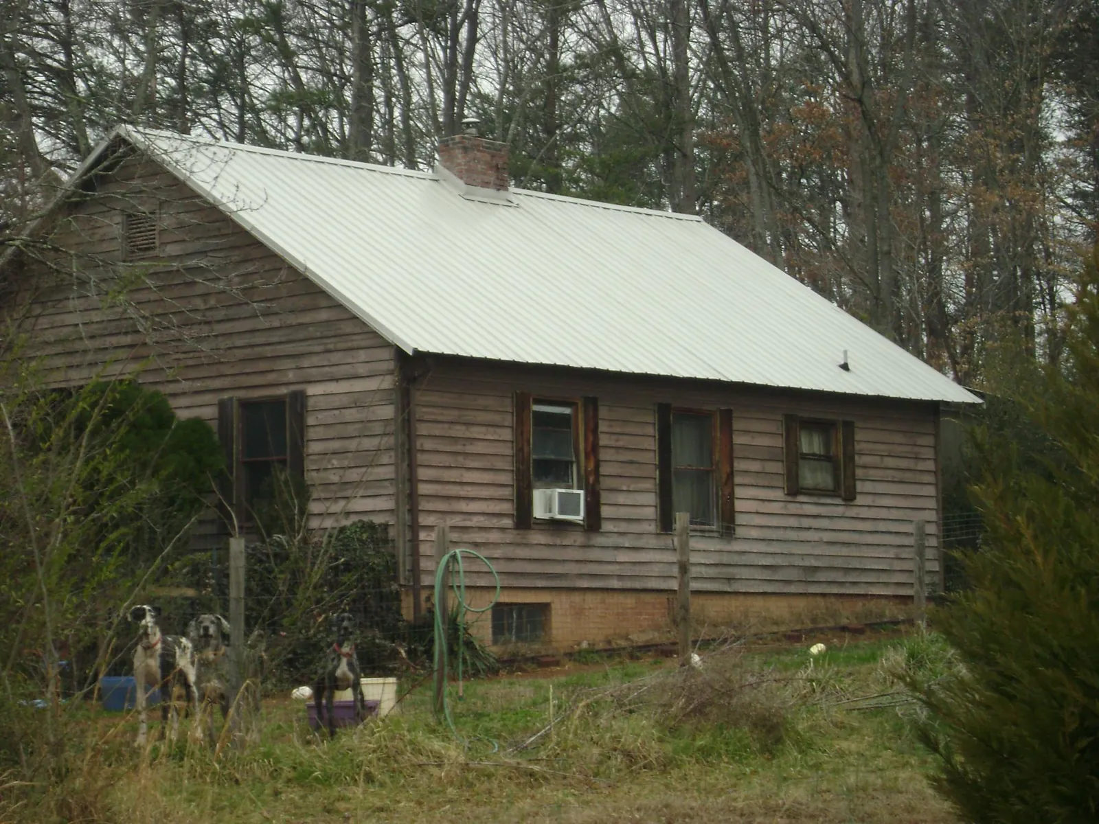 White metal roof on an old wood sided farmhouse, from a Metal Roof Installation job in Deanville
